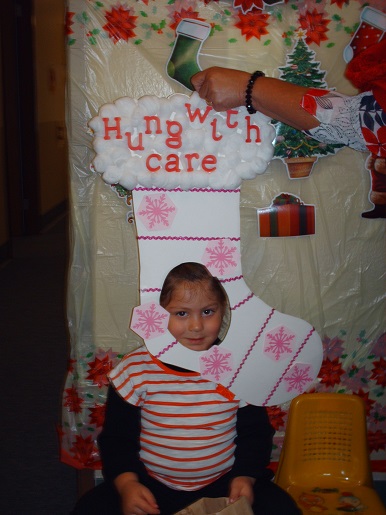 A child holding a sign that says hung with care